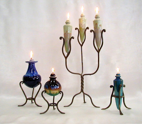 asortment of stoneware oil lamps on forged iron bases, variedad de lamparas de aceite en ceramica de alta temperatura con esmaltes reactivos sobre bases de hierro forjado